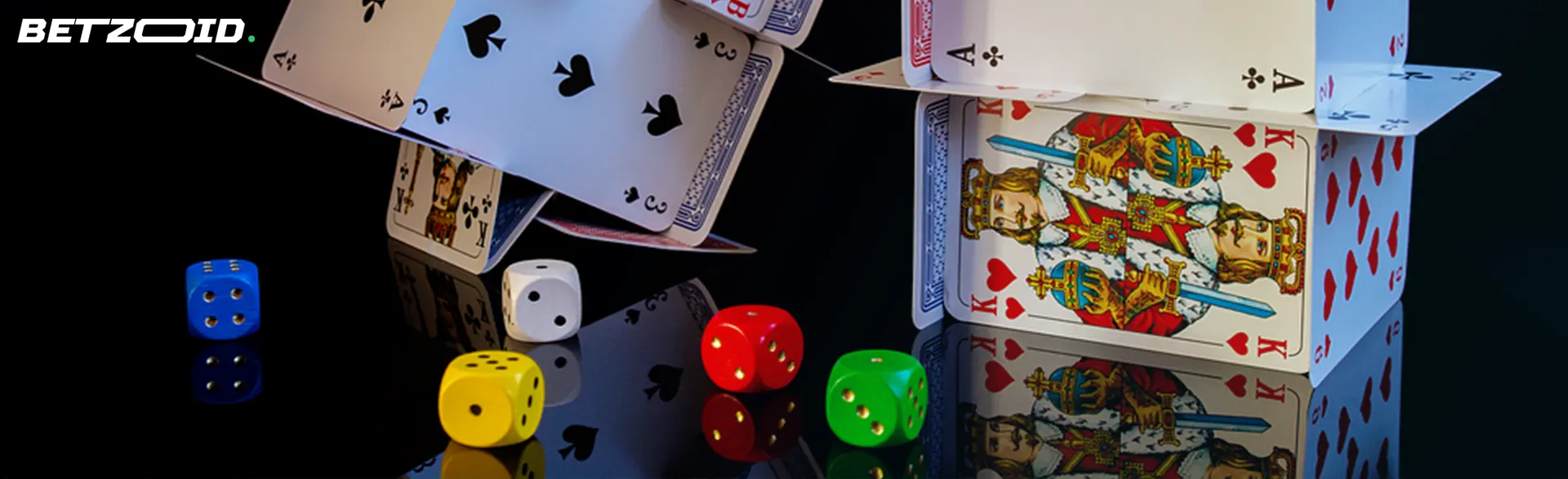 A card house with kings and aces, surrounded by colorful dice on a dark background.